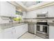 Charming kitchen featuring white cabinets, stainless steel appliances, and granite countertops at 279 Mariner Ln, Rotonda West, FL 33947