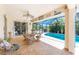 Charming outdoor patio with wicker furniture, perfect for relaxing by the screened-in pool at 279 Mariner Ln, Rotonda West, FL 33947