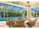 Cozy outdoor patio featuring comfortable seating and a serene view of the sparkling pool and lush greenery at 279 Mariner Ln, Rotonda West, FL 33947