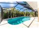 Inviting screened-in pool area with tropical landscaping offers a private and serene outdoor retreat at 279 Mariner Ln, Rotonda West, FL 33947
