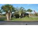 Community pool area surrounded by lush tropical landscaping, an American flag, and a screened-in pool for residents at 4056 Oakview Dr # E10, Port Charlotte, FL 33980