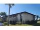 This is an exterior view of the multi-Gathering residence with well-maintained landscaping and a clear blue sky at 4056 Oakview Dr # E10, Port Charlotte, FL 33980