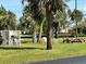 Picnic area featuring a grill, mature trees, and lush landscaping at 4056 Oakview Dr # E10, Port Charlotte, FL 33980
