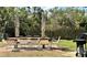 Outdoor dining area with table, chairs, grill, and privacy provided by trees and shrubbery at 4056 Oakview Dr # E10, Port Charlotte, FL 33980