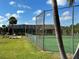 Tennis court featuring lush landscaping and community pool beyond the fence line at 4056 Oakview Dr # E10, Port Charlotte, FL 33980