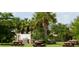 Community picnic area with multiple tables, grill, mature trees, and lush landscaping at 4056 Oakview Dr # E10, Port Charlotte, FL 33980