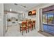 Open kitchen features white cabinets, granite countertops, an island with seating, and access to an outdoor area at 4231 Hollis Ave, Port Charlotte, FL 33953