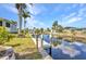 Scenic waterfront view with a private dock, palm trees, and serene water reflecting the sky at 4231 Hollis Ave, Port Charlotte, FL 33953
