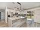 Modern kitchen featuring an island with stone countertop and stainless steel appliances at 4282 Pocatella Ave, North Port, FL 34287