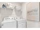 Efficient laundry room with a modern washer and dryer set and shelving for storing laundry essentials at 4911 Schubert Trl, North Port, FL 34287