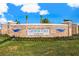 Entrance to Central Parc at North Port featuring brick signage, lush landscaping, and a bright blue sky at 4967 Tuscola Blvd, North Port, FL 34287