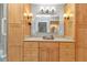 Bathroom featuring a granite countertop, wood cabinetry, decorative bowl sink and vanity lights at 5046 San Rocco Ct, Punta Gorda, FL 33950