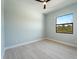 Bright bedroom with modern ceiling fan fixture and a window showing backyard greenery at 7149 Sea Mist Dr, Port Charlotte, FL 33981
