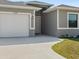 View of the home's exterior showcasing the garage, siding, and concrete driveway at 7149 Sea Mist Dr, Port Charlotte, FL 33981