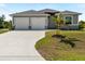 Charming single-story home featuring a well-manicured lawn, a spacious two-car garage, and a welcoming front entrance at 7149 Sea Mist Dr, Port Charlotte, FL 33981