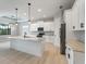 Modern kitchen boasts a large island with bar seating, stainless steel appliances, and elegant pendant lighting at 7149 Sea Mist Dr, Port Charlotte, FL 33981