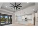Bright, open-concept living space boasts stylish light fixtures and leads to a modern kitchen and sliding glass doors at 7149 Sea Mist Dr, Port Charlotte, FL 33981