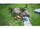 Stunning aerial view of a single-story home with a lush lawn, tropical trees, and a wide driveway at 7505 Carissa, Punta Gorda, FL 33955
