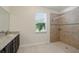Bathroom showcasing granite vanity, walk-in shower with tiled surround, and a bright window at 7505 Carissa, Punta Gorda, FL 33955