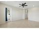 A minimalist bedroom featuring tile flooring, ceiling fan, and an entrance to the patio at 7505 Carissa, Punta Gorda, FL 33955
