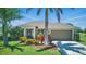 Charming single-story home featuring a well-manicured lawn, tropical landscaping, and a two-car garage at 7505 Carissa, Punta Gorda, FL 33955