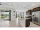 Open kitchen with granite counters, dark wood cabinetry, stainless steel appliances, and pendant lighting above the island at 7505 Carissa, Punta Gorda, FL 33955
