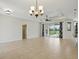 Bright open-concept living room boasts tile flooring, a chandelier, and seamless access to the outdoor pool area at 7505 Carissa, Punta Gorda, FL 33955