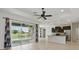 Spacious living area with modern tile floors, ceiling fan, and sliding glass doors to the screened lanai and pool area at 7505 Carissa, Punta Gorda, FL 33955