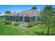 Well-maintained home featuring a screened-in pool area and lush green lawn with manicured landscaping at 7505 Carissa, Punta Gorda, FL 33955