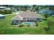 Rear view of home with a screened-in pool, lush landscaping, and well-maintained lawn under a clear blue sky at 7505 Carissa, Punta Gorda, FL 33955