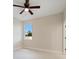 Bright bedroom featuring a ceiling fan, window overlooking a green landscape, and neutral paint at 8849 Attalla Ave, North Port, FL 34287