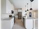 Well-lit kitchen with a marble countertop, stainless appliances, and stylish white cabinetry at 8849 Attalla Ave, North Port, FL 34287
