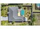 Aerial view of a well-maintained home with a backyard pool, wooden deck, shed, and fenced yard at 9295 Melody Cir, Port Charlotte, FL 33981
