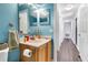 Bright blue bathroom features a single sink vanity, a toilet, and tile floors at 9295 Melody Cir, Port Charlotte, FL 33981