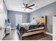 Gray bedroom with ceiling fan, wood floors, headboard and stylish modern furniture at 9295 Melody Cir, Port Charlotte, FL 33981