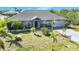 Charming home with manicured lawn, palm trees, and tasteful landscaping enhances curb appeal at 9295 Melody Cir, Port Charlotte, FL 33981