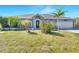 Charming single-story home featuring a well-manicured lawn and tropical landscaping, offering curb appeal at 9295 Melody Cir, Port Charlotte, FL 33981