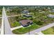 An aerial view of this single-story home shows its manicured lawn, lush landscaping, and long driveway at 10233 St Paul Dr, Port Charlotte, FL 33981