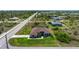 Aerial view of single-story home shows pristine lawn, mature landscaping, and long driveway at 10233 St Paul Dr, Port Charlotte, FL 33981