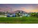 Stunning exterior with lush lawn, mature landscaping and striking architectural details at sunset at 10233 St Paul Dr, Port Charlotte, FL 33981