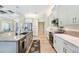 Modern kitchen featuring white cabinets, stainless steel appliances, granite countertops, and a view to the living area at 10233 St Paul Dr, Port Charlotte, FL 33981