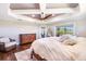 Comfortable main bedroom with tray ceiling, wood floors, and view to the outdoor lanai at 10233 St Paul Dr, Port Charlotte, FL 33981