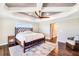 A lovely main bedroom featuring tray ceilings, a ceiling fan, and decorative bed frame at 10233 St Paul Dr, Port Charlotte, FL 33981