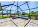 Screened-in patio area featuring comfortable furniture, tile floors, and a peaceful garden view at 10233 St Paul Dr, Port Charlotte, FL 33981