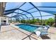 Screened in pool area including pavers and two in-pool lounging chairs perfect for relaxation at 10233 St Paul Dr, Port Charlotte, FL 33981