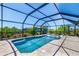 A clear view of a screened-in pool with in-pool loungers and an unobstructed view at 10233 St Paul Dr, Port Charlotte, FL 33981