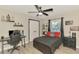 This bedroom features wood floors, a ceiling fan, a desk with a gaming chair and shelf decor at 1321 Calgary Rd, North Port, FL 34288