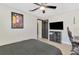 This bedroom features wood floors, a ceiling fan, a mounted television and dark accent doors at 1321 Calgary Rd, North Port, FL 34288
