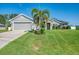 Charming single-story home featuring stone accents, a well-manicured lawn, and a two-car garage, with a palm tree in the front yard at 1321 Calgary Rd, North Port, FL 34288