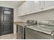 Efficient laundry room with modern washer and dryer, granite countertop, and white cabinets at 1321 Calgary Rd, North Port, FL 34288
